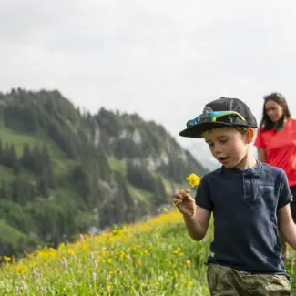Un enfant et sa maman jouant dans les prés de Charmey