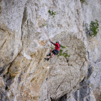 Un homme grimpe la paroi de la via ferrata de Charmey