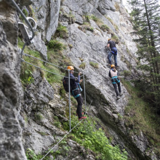 Un groupe d'adultes se trouvent sur le parcours de la via ferrata