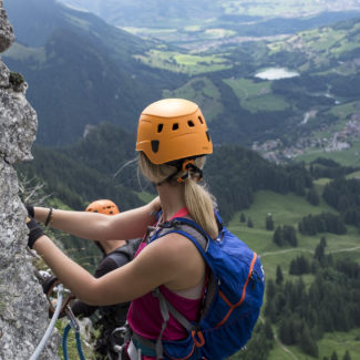 Une femme sur la via ferrata profite de la vue sur la vallée à Charmey