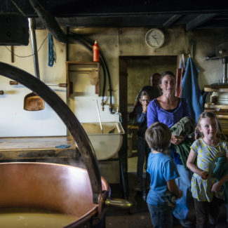 Une famille visite les locaux où est fabriqué le fromage à Charmey