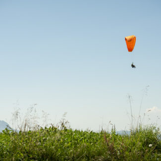 un parapente survole les prés de Charmey