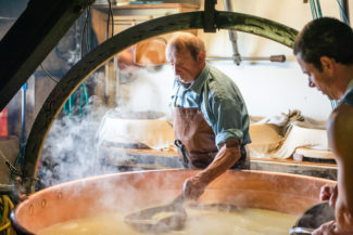 Deux fromagers sont en train de créer du fromage à Charmey