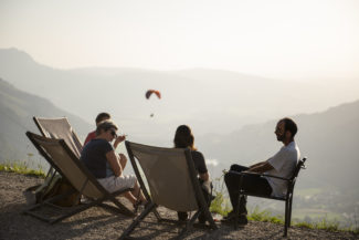 Un groupe d'amis se détend sur des transats avec vue sur la vallée de Charmey