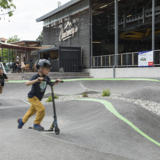 Un enfant en trottinette s'entraine sur le pumptrack à Charmey