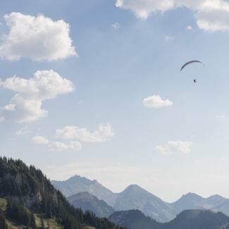 Une vue panoramique depuis le sommet de Vounetz avec un parapente au loin