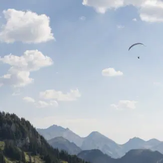 Une vue panoramique depuis le sommet de Vounetz avec un parapente au loin