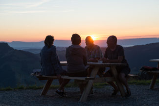 Un groupe d'amis profitant de l'apéritif sur la terrasse au soleil couchant à Charmey