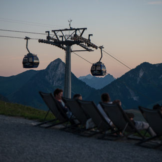 Des personnes sont installé sur des transats pour admirer le couchez de soleil depuis le sommet de Vounetz