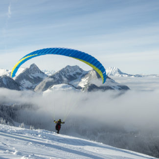 Un parapente est sur le point de décoller sur la vallée enneigée de Charmey