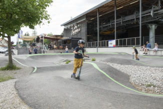 un enfant en trottinette sur la pumptrack de Charmey