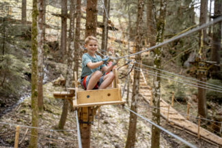 Un enfant s'amuse à l'accrobranche de Charmey